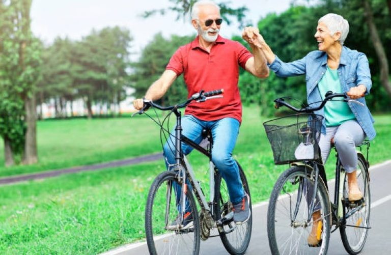 Portrait of happy smiling senior couple on bicycles outdoors
